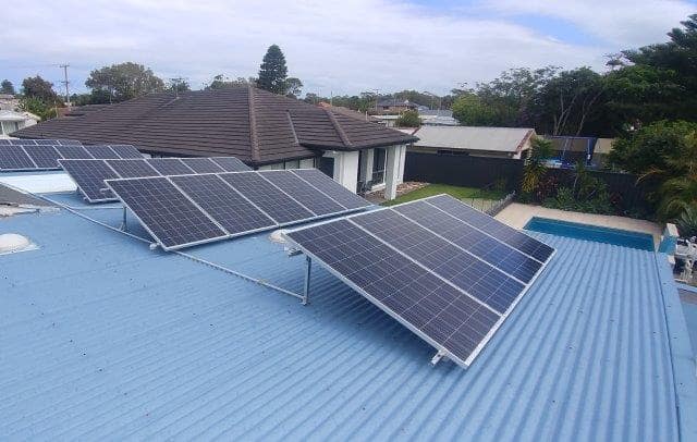 multiple solar panels on blue flat roof